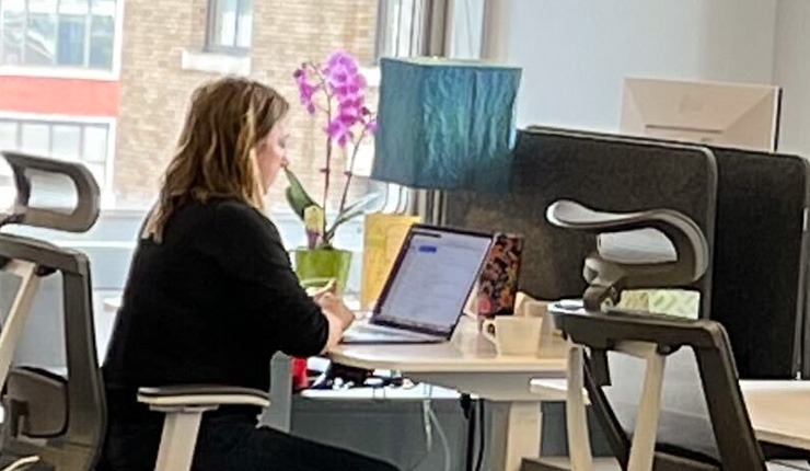 A member working on her laptop at her desk