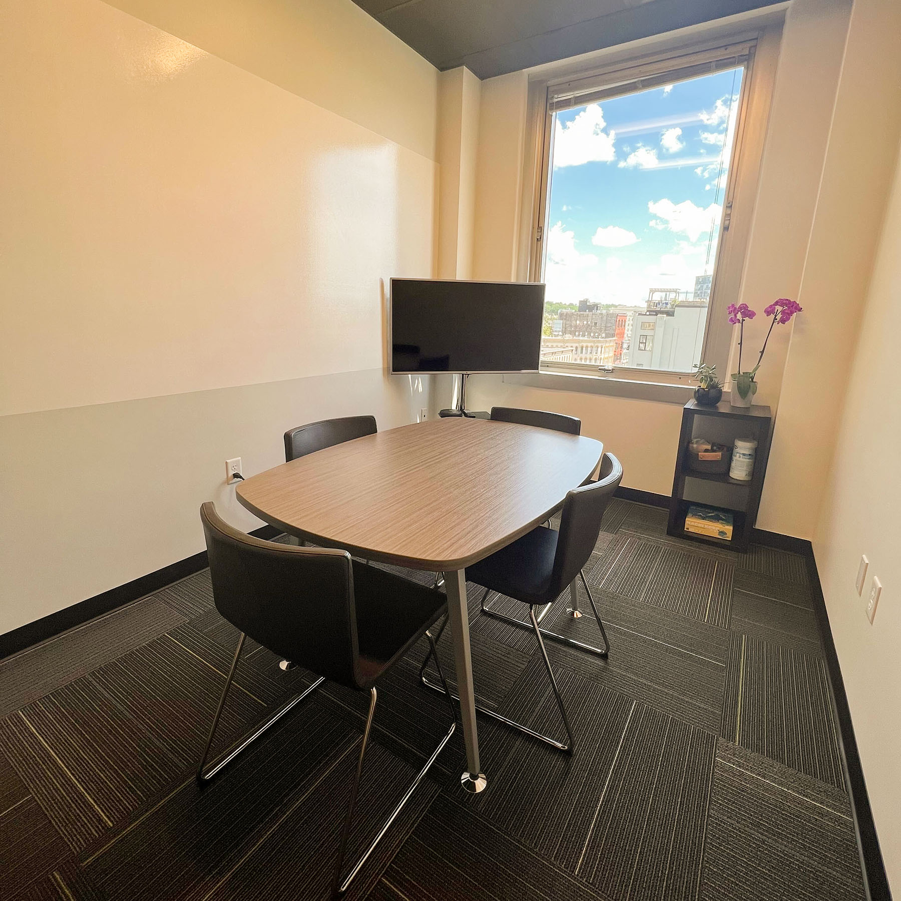 Our West Side conference room with 3 tables and tv next to a white board wall